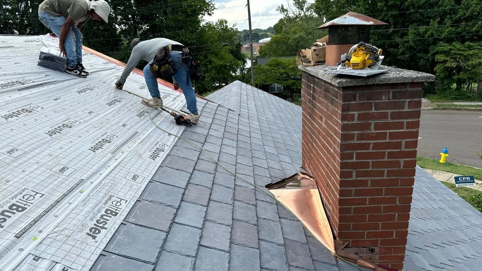 roofers checking deck and underlayment during a mid-roof inspection